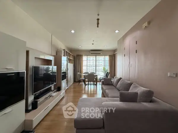 Spacious living room with modern decor and large windows offering city views.