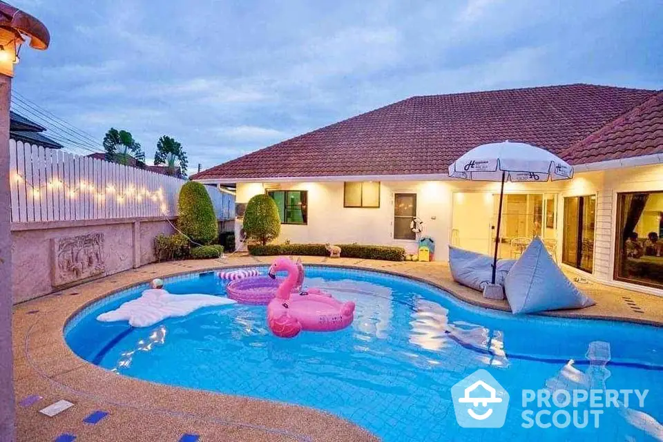 Charming villa with inviting pool and playful inflatables, perfect for relaxation and entertainment.