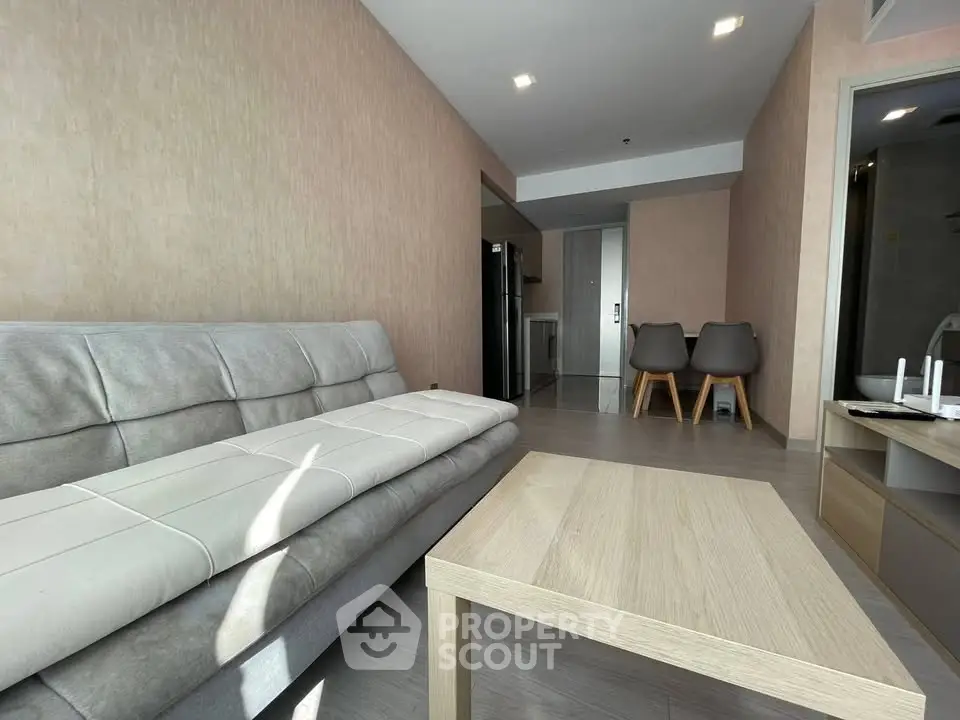 Modern living room with sleek furniture and open layout, featuring a cozy sofa and stylish dining area.