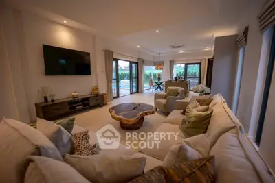 Luxurious living room with modern decor and large windows overlooking a serene outdoor view.