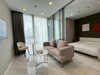 Modern studio apartment with elegant decor and floor-to-ceiling windows