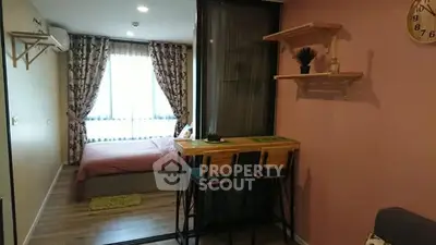 Cozy bedroom with stylish decor and natural light, featuring a small dining area and modern furnishings.