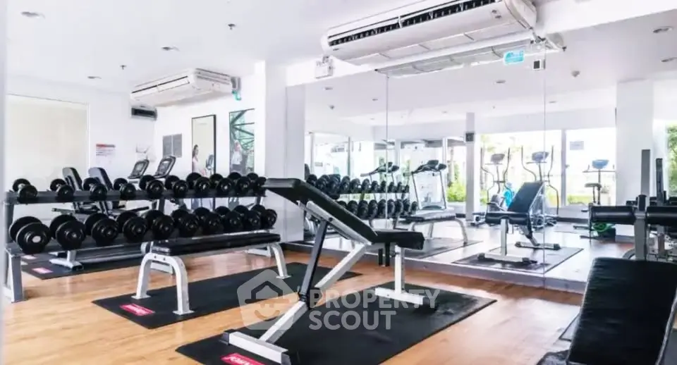 Modern gym with state-of-the-art equipment and mirrored walls in a luxury residential building.