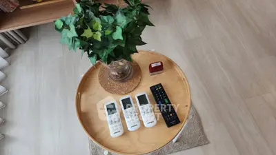 Modern living room with stylish round table and remote controls