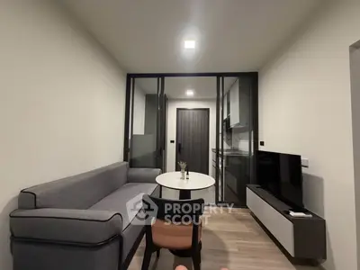 Modern living room with sleek furniture and glass partition in a stylish apartment.