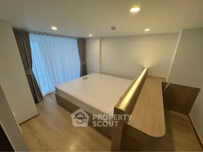 Modern bedroom with wooden flooring and large window with curtains