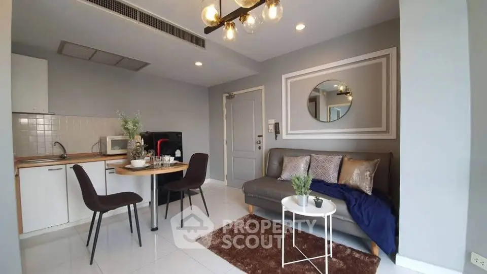 Modern living room with open kitchen, stylish decor, and cozy seating area.
