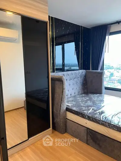 Modern bedroom with large mirrored wardrobe and city view