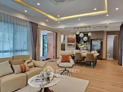 Luxurious open-concept living and dining area with modern decor and elegant lighting.