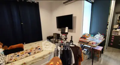 Cozy bedroom with modern decor, featuring a wall-mounted TV and exercise equipment, perfect for urban living.