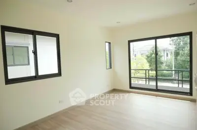 Spacious empty room with large windows and balcony view in modern home