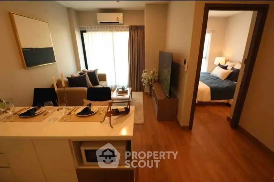 Modern open-plan living room with cozy bedroom view, stylish decor, and natural light.