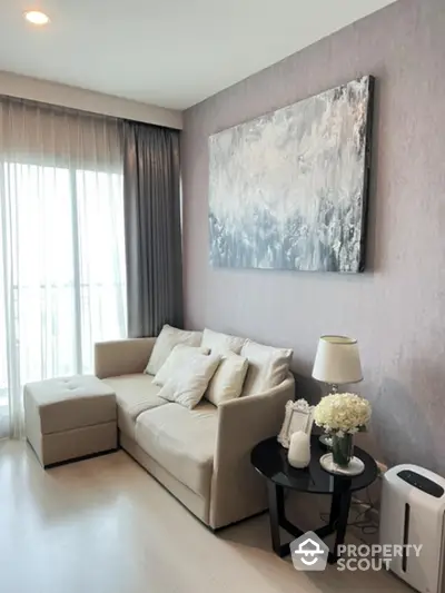 Elegant living room with plush beige sofa, modern art, and soft lighting, perfect for relaxation in a chic urban home.