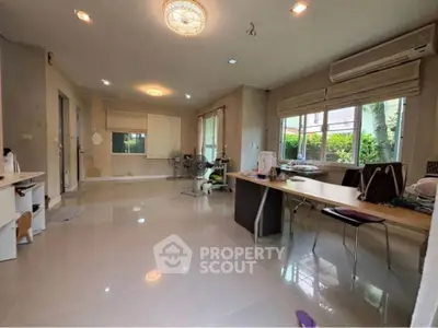 Spacious living room with modern lighting and large windows offering natural light.