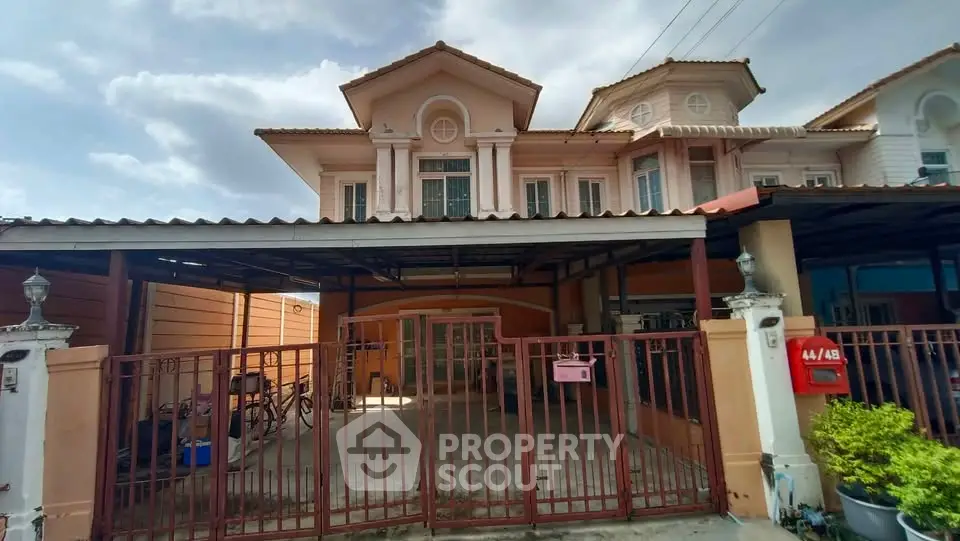 Charming two-story house with gated parking and classic architectural design.