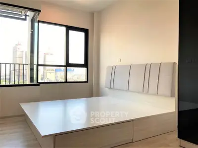 Modern bedroom with large window and city view, featuring a stylish bed and sleek design.