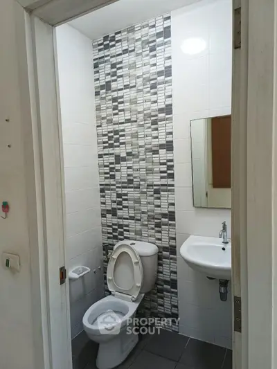 Modern bathroom with stylish tile accent wall and compact fixtures