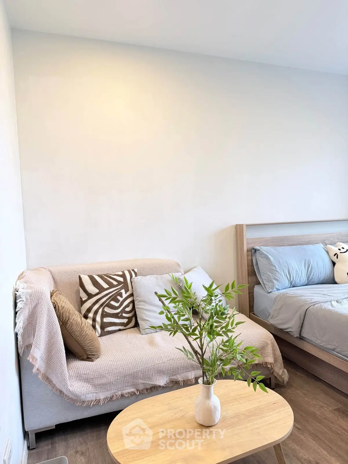 Cozy bedroom with stylish decor and comfortable seating area, perfect for relaxation.