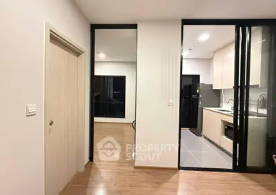 Modern apartment interior with sleek kitchen and open layout, featuring wooden flooring and contemporary design.