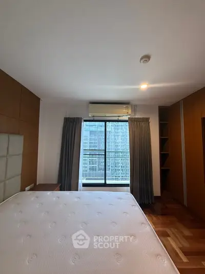 Spacious bedroom with city view and elegant wooden flooring