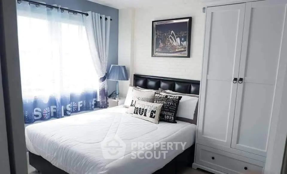 Cozy bedroom with stylish decor and ample natural light, featuring a comfortable bed and modern wardrobe.