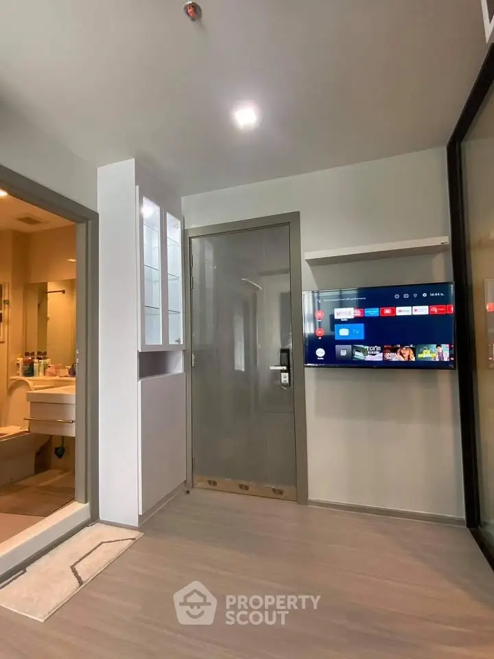 Modern apartment interior with sleek TV setup and bathroom view