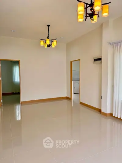 Spacious living room with elegant lighting and tiled flooring in modern home.