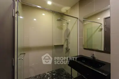 Modern bathroom with glass shower and sleek black sink