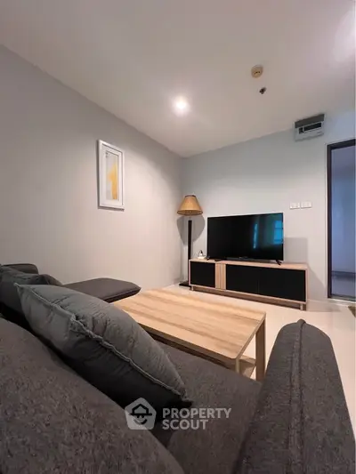 Modern living room with cozy sofa and flat-screen TV, perfect for relaxation and entertainment.