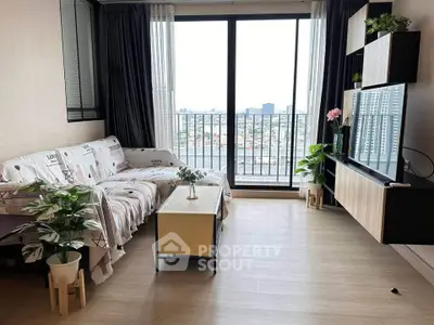 Modern living room with balcony view, stylish decor, and natural light in urban apartment.