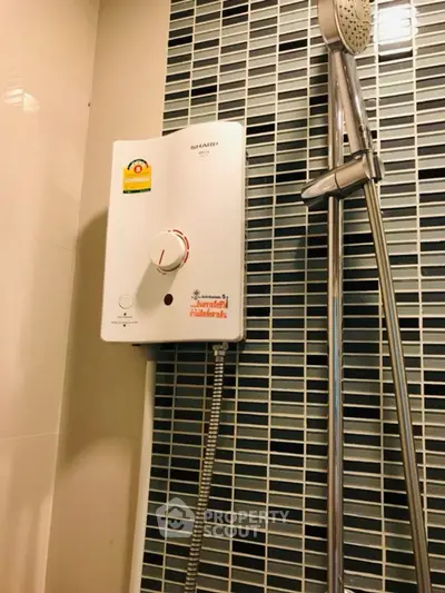 Modern bathroom with sleek shower and water heater installation.