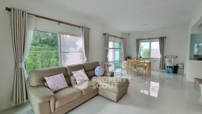 Spacious living room with modern decor and large windows offering garden views.