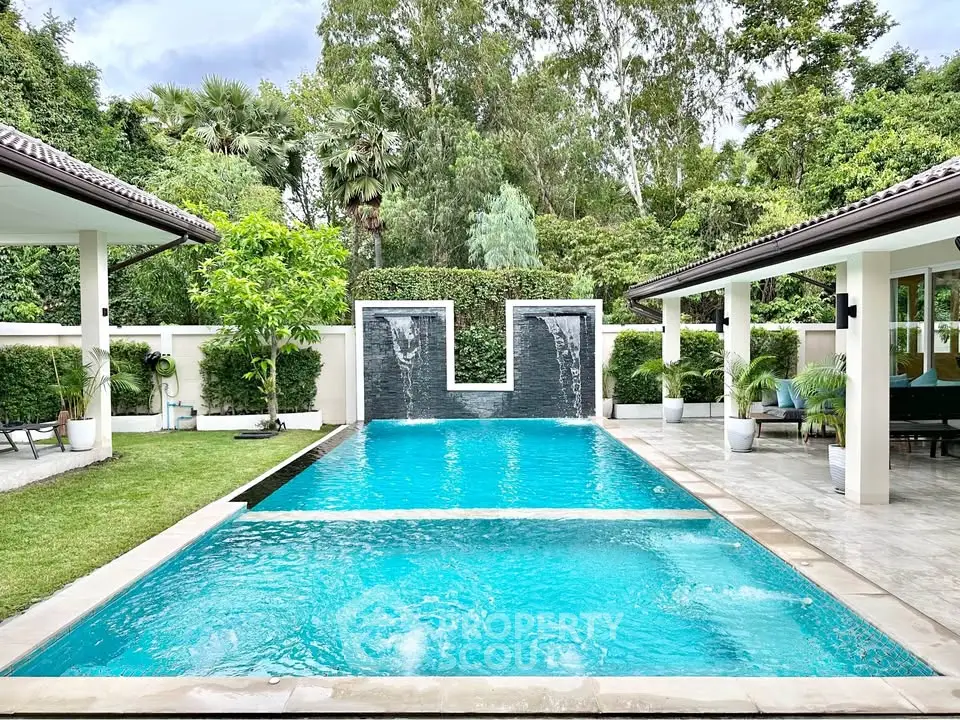 Luxurious outdoor pool with waterfall feature in a serene garden setting, perfect for relaxation and entertainment.
