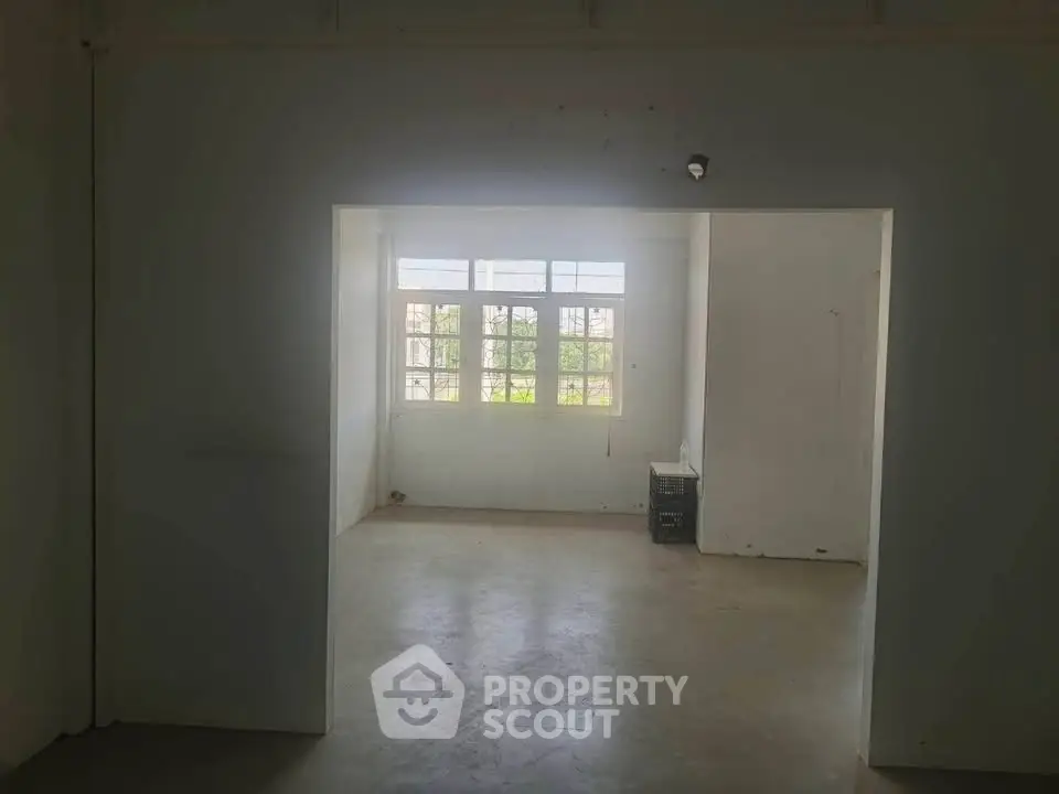 Spacious empty room with large window and natural light