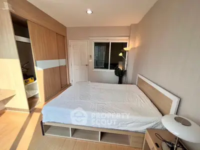 Spacious bedroom with modern design, large window, and ample storage in a stylish apartment.