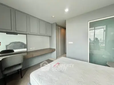 Modern bedroom with built-in wardrobe and city view, featuring sleek design and ample natural light.