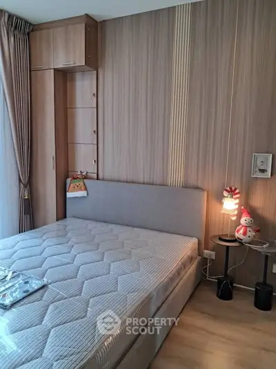 Cozy bedroom with modern decor and ample natural light, featuring a comfortable bed and stylish wooden accents.