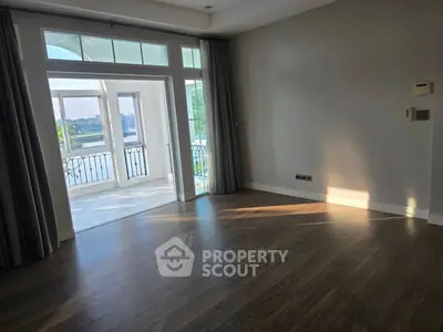 Spacious living room with large windows and balcony offering stunning views, perfect for modern living.