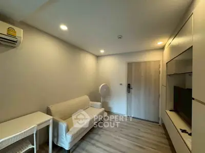 Modern living room with sleek design, featuring a cozy sofa, built-in storage, and ambient lighting.