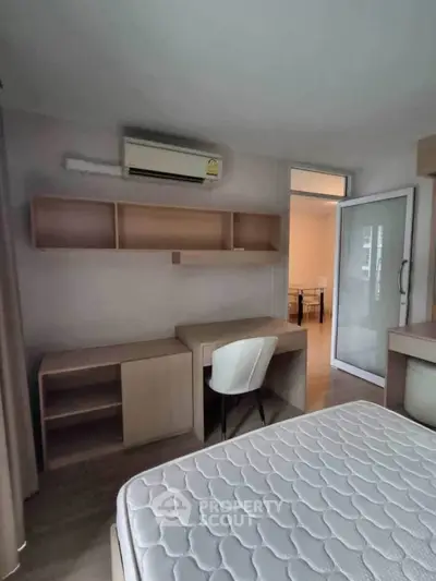 Cozy bedroom with study desk and air conditioning, perfect for comfortable living.