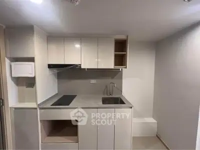 Modern compact kitchen with sleek cabinetry and integrated appliances in a minimalist design.