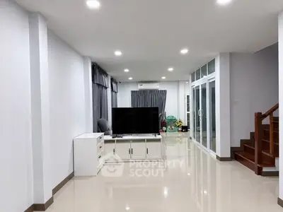 Spacious modern living room with sleek design and large TV setup