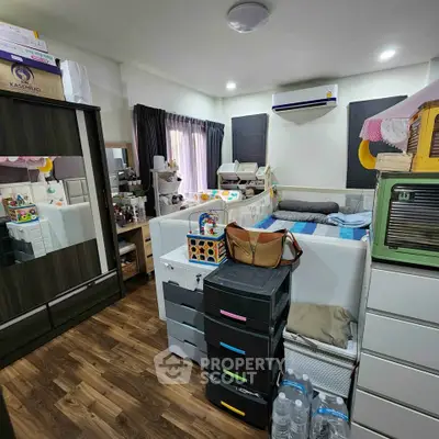 Cozy bedroom with modern decor and ample storage solutions, featuring a stylish wardrobe and air conditioning.