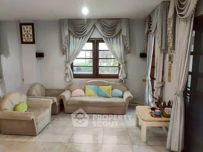 Charming living room with elegant drapes and cozy seating, perfect for relaxation and entertaining.