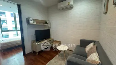Cozy living room with modern decor and adjacent bedroom view in a stylish apartment.