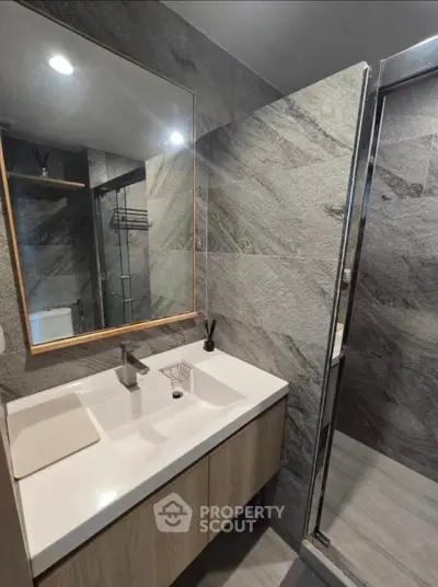 Modern bathroom with sleek vanity and glass shower enclosure