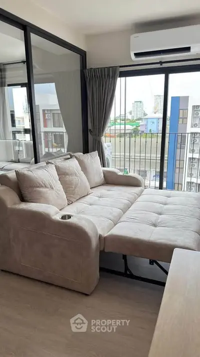 Modern living room with plush sofa and city view balcony, perfect for urban living.