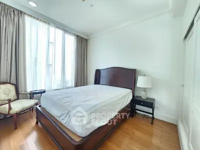Spacious bedroom with elegant wooden bed and natural light