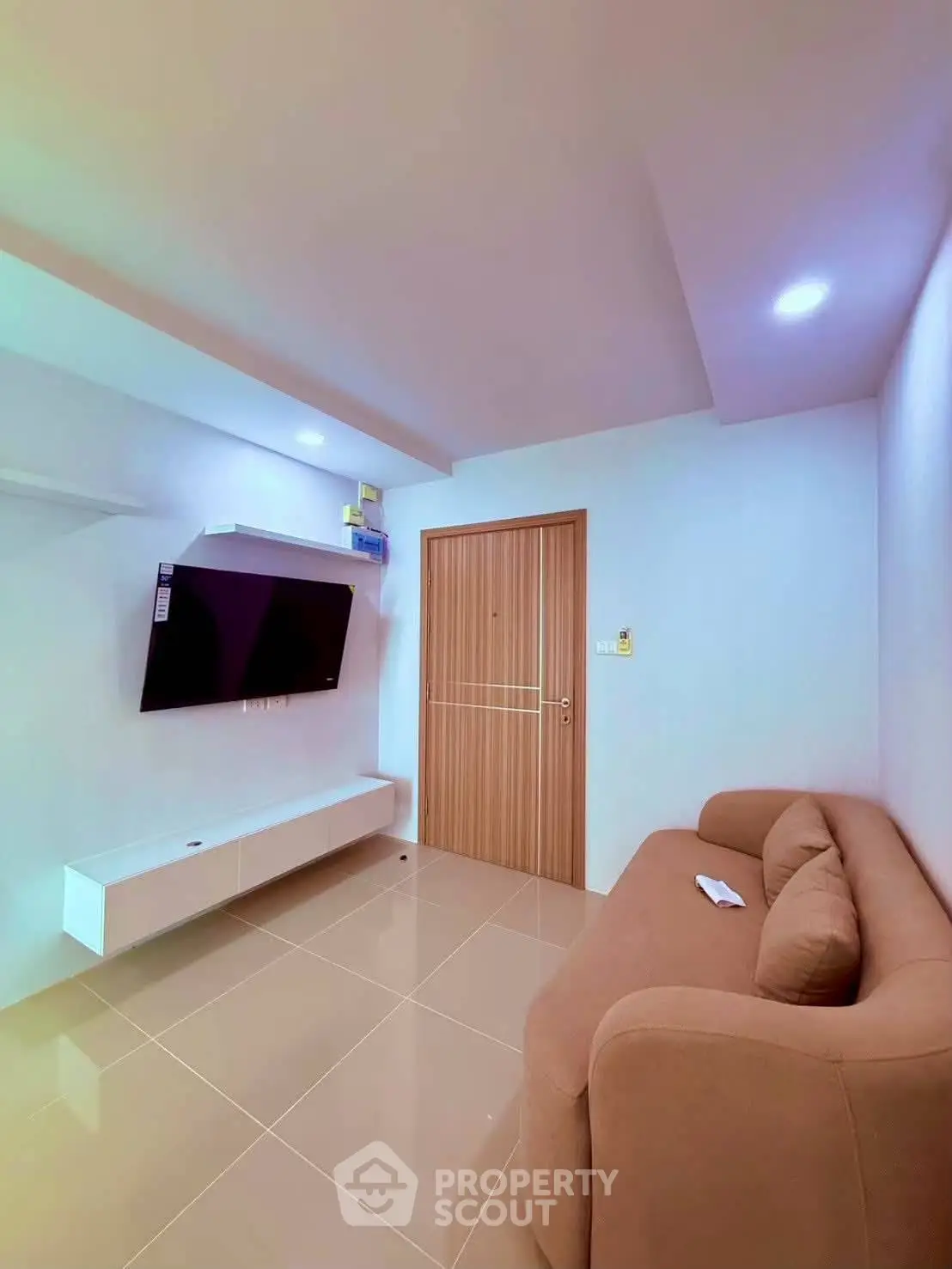 Modern living room with sleek TV setup and cozy sofa in a stylish apartment.