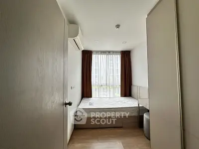 Modern bedroom with large window and minimalist design, featuring a comfortable bed and ample natural light.